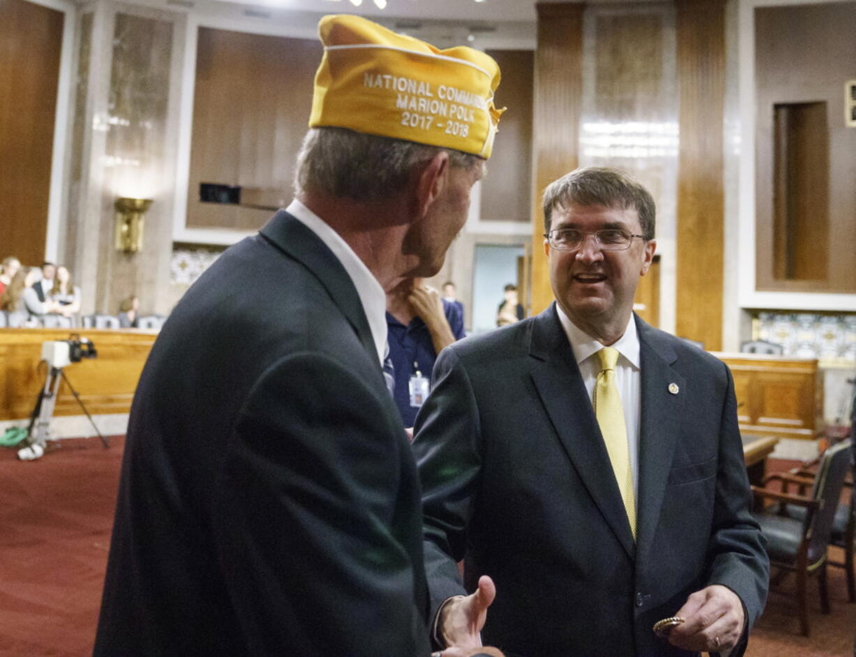 Veterans Affairs Secretary nominee Robert Wilkie, right, speaks with Marion Polk, National Commander of AMVETS, before he testifies during a Senate Veterans Affairs Committee nominations hearing on Capitol Hill in Washington, Wednesday, June 27, 2018.