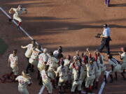 Florida State catcher Anna Shelnutt (13) celebrates her home run as she runs toward her teammates waiting at home plate in the first inning.