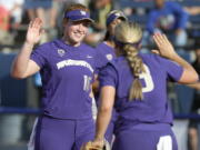 Washington’s Gabbie Plain (16) celebrates with Taylor Van Zee (3) after the second inning of an NCAA softball Women’s College World Series game against Oregon in Oklahoma City, Friday, June 1, 2018.