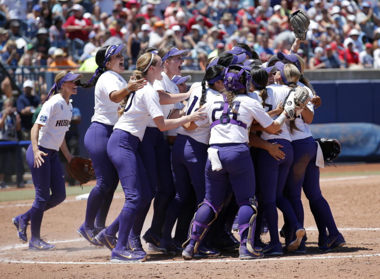 Washington celebrates their win over Oklahoma following a Women’s College World Series NCAA softball game in Oklahoma City, Sunday, June 3, 2018.