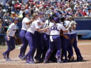 Washington celebrates their win over Oklahoma following a Women’s College World Series NCAA softball game in Oklahoma City, Sunday, June 3, 2018.