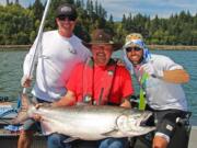 Buzz Ramsey, center, and friends celebrate landing a 32-pound Chinook caught last year at Buoy 10. Chinook could be in short supply this season.