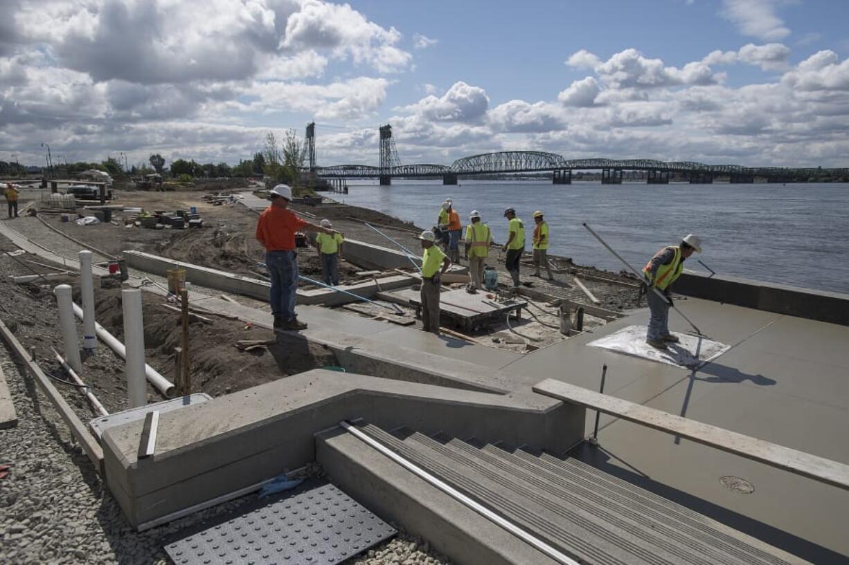 Construction crews works at The Waterfront Vancouver, near where the park and water feature meet the Grant Street Pier. The city of Vancouver announced Friday that it will host a grand opening for the park on Sept. 29.