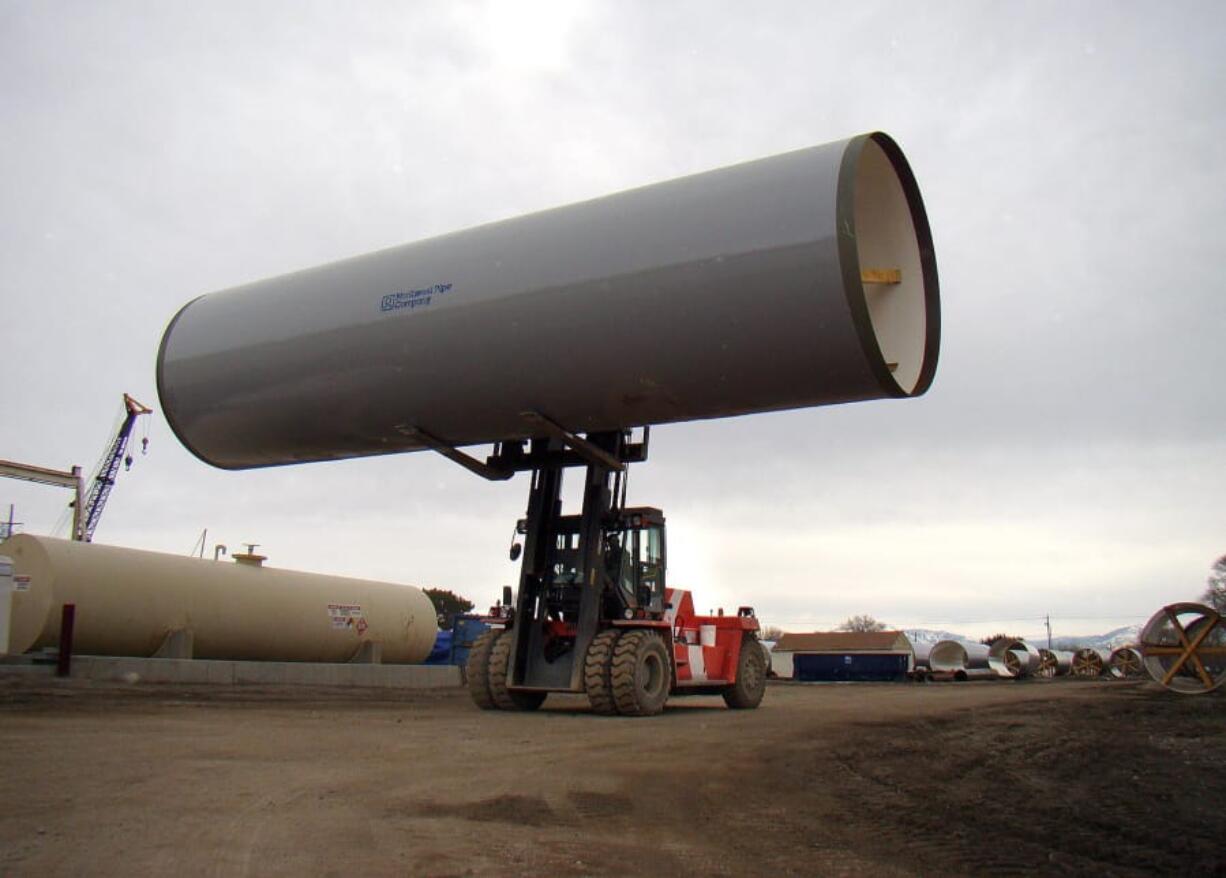 A finished section of pipe is moved by a forklift at a Northwest Pipe Company location in Utah in 2011. The company, which has moved to focus solely on the water business, has acquired a California maker of welded steel pressure pipe and reinforced concrete pipe to expand its business.