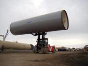 A finished section of pipe is moved by a forklift at a Northwest Pipe Company location in Utah in 2011. The company, which has moved to focus solely on the water business, has acquired a California maker of welded steel pressure pipe and reinforced concrete pipe to expand its business.