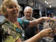 Debbie Wright and Rollie Mayberry, center, recently retired as barbers at Cecil’s Barber Shop, with a combined 105 years of barbershop experience.