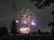 The lights of an airplane streak through fireworks as they light the night sky above Fort Vancouver National Historic Site and Pearson Field on Wednesday evening.