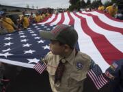 Ethan Dulay, 10, of Cub Scout Pack 310 of Ridgefield spends a quiet moment with the American flag while preparing for the start of the annual Ridgefield Fourth of July parade Wednesday morning. Dulay said this was his first year participating in the parade and said he was excited for the holiday. "I just like everything," he said. The theme of this year's parade was "Over There, Over There: 100 Years of the American Legion." The pack is chartered by the American Legion Post 44 in Ridgefield.