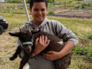 Hazel Dell: Ellsworth Elementary School fifth-grader Isaiah Ashenfelter holding a goat during Washington State University Extension’s Supplemental Nutrition Assistance Program Education’s Farm-to-Fork event.