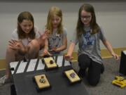 Washougal: Hathaway Elementary School third-graders, from left, Alexis Wright, London Hickey and Violet Cole at a workshop hosted by the Oregon Museum of Science and Industry where girls were asked to design and test a car.