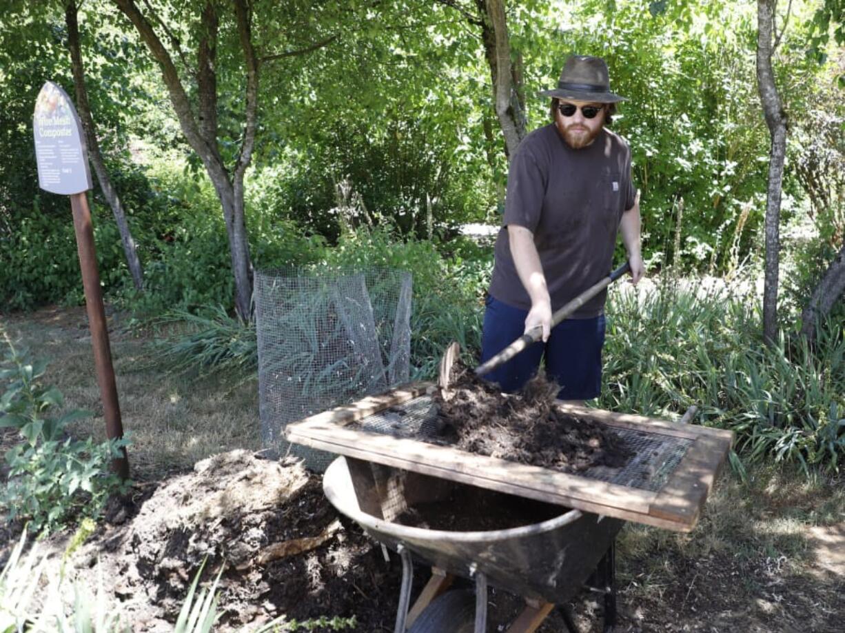 Eric Stricker, a volunteer with Clark County Green Schools, demonstrates filtering larger chunks due back to the pile from compost soil during a demonstration and open house on composting Sunday at the Art in the Garden event in Brush Prairie.