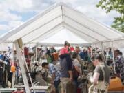 Shoppers at the NW’s Largest Garage Sale & Vintage Sale browse under a shaded stall at the Clark County Event Center at the Fairgrounds on Saturday. Organizers said there were 500 vendors there hoping to sell to thousands of shoppers.