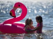 Cana Brown, 7, left, and Myranda Benson, 5, both of Washougal, play together at Cottonwood Beach in Washougal on July 11. Myranda's mother, Myrna, said this is their first time visiting the beach. “I love it,” she said.