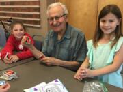 Ridgefield: Union Ridge Elementary School second-graders Lizzy Bloom, left, and Clara Bruguier, right, play cards with Ken Carson at the Ridgefield Community Center during a monthly visit to meet with local seniors.