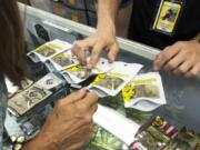 Evie Wilson of Hazel Dell, left, looks at a selection of marijuana while shopping at Sticky’s Pot Shop. The Hazel Dell pot shop faces imminent closure due to a ban on recreational marijuana sales in unincorporated Clark County, and the shop spent Thursday encouraging shoppers to vote in November, when two seats and the chair of Clark County Council are up for reelection.