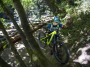 Scott McClelland of Portland carries his bike up an incline near the intersection of Lacamas McEnry and Red Tape trails in Lacamas Regional Park. Clark County Parks has designated the Red Tape trail as a bikes-only route, the first of its kind in the Clark County park system.