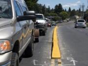 A recently installed median on Northeast Minnehaha Street stands out with its fresh coat of paint. But farther down the line, there’s a black mark where portions of it were removed after business owners complained.