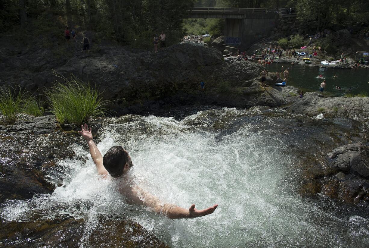 Christopher Cornwell of Portland takes in the view as he cools off at the top of Dougan Falls as temperatures hover around 100 degrees July 15. Another heat wave is expected to hit the area Sunday and push daily high temperatures above 90 degrees throughout the coming week.