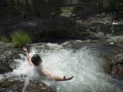 Christopher Cornwell of Portland takes in the view as he cools off at the top of Dougan Falls as temperatures hover around 100 degrees July 15. Another heat wave is expected to hit the area Sunday and push daily high temperatures above 90 degrees throughout the coming week.