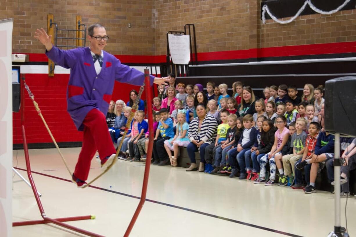 Woodland: Rhys Thomas juggles multiple items while balancing on a tightrope during his educational performance at Woodland Primary School.