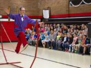 Woodland: Rhys Thomas juggles multiple items while balancing on a tightrope during his educational performance at Woodland Primary School.