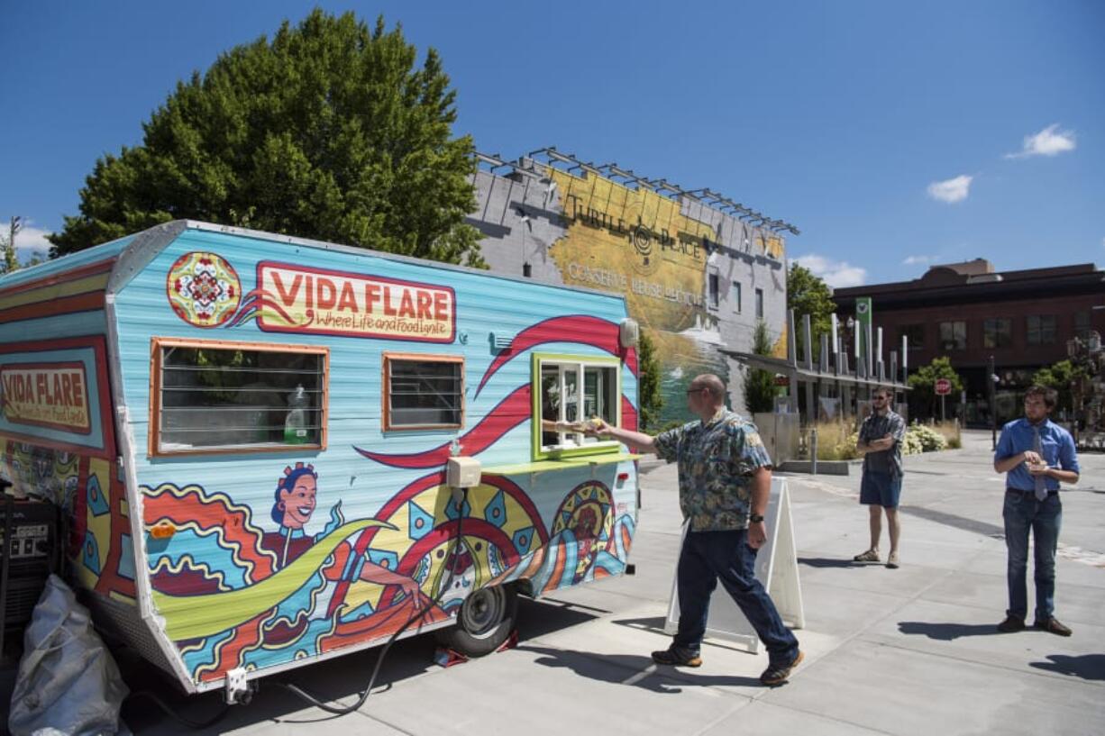 Josh Pope of Wilsonville, Ore., grabs lunch from the window at Vida Flare. Pope and his co-workers, who work across the street, said they, like many nearby workers and residents, are eager for more food options.