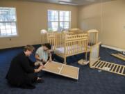 Infant teacher Breanna Levesque, left, and child care supervisor Trista Dunford put together cribs for the Pregnant and Parenting Women’s Program at the Women’s Recovery Center in Vancouver on Tuesday.