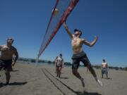 Michael Erickson, 16, of Vancouver, right, charges the net while playing a friendly pick-up volleyball game with family and friends at Frenchman's Bar Regional Park on Monday afternoon. Erickson said he planned to escape the heat and cool off in the nearby water following the game.