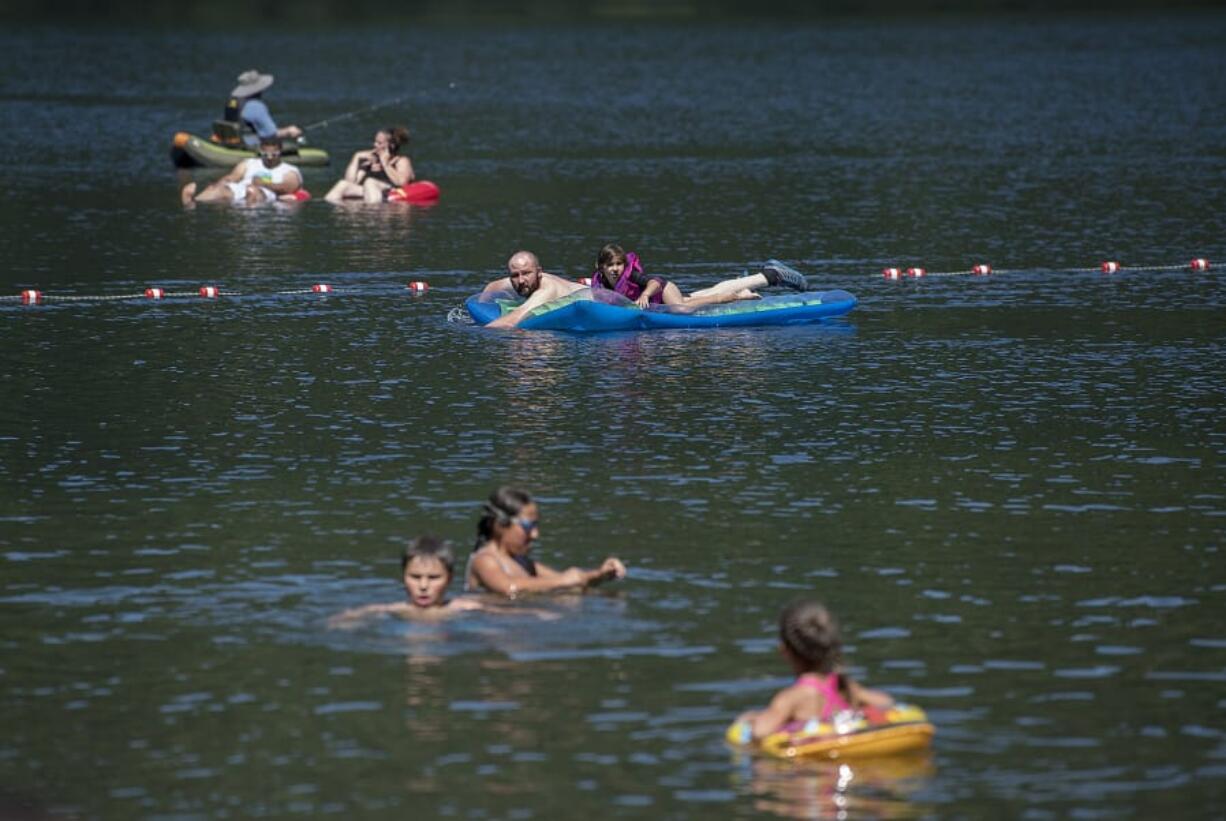 Swimmers and fishermen escape the summer heat at Battle Ground Lake State Park on Monday.