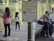 A sign at Battle Ground Lake State Park warns visitors of the possibility of increased levels of bacteria in the water in July 2018. Tests over the weekend showed no sign of the bacteria, and heath officials say signs will be removed if follow-up tests Monday verify that result.