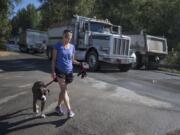 Rachel Grice and her dog, Rusty, 3, take their morning stroll just as truck traffic from a nearby mine picks up.