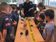 Battle Ground: Battle Ground Police Department Lt. Kim Armstrong shows a Battle Ground-based Cub Scouts pack a crime scene during the pack’s visit to the station.