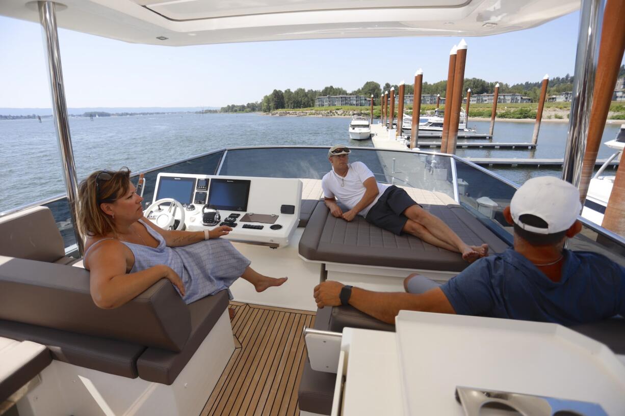 Jennifer Heredia, from left, Tim Hazen and Marcelo Heredia take a detour from the boats on offer for mere mortals to check out one of the multimillion-dollar luxury yachts on display at Tidewater Cove Boat Show Sunday.