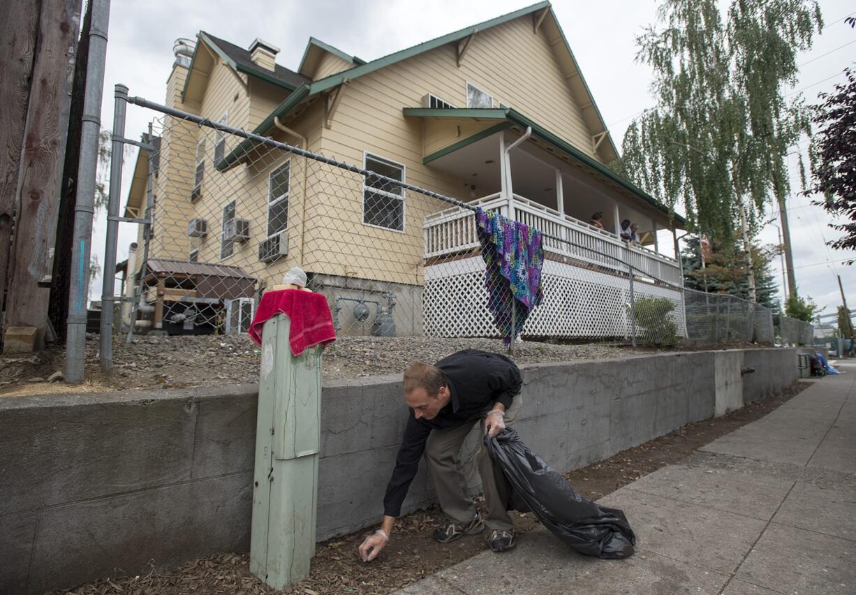 A Share House resident picks up around the exterior of the building in 2016.  Share's kitchen and public restrooms are currently closed for remodeling. Although water to the ground floor was shut off and the entrance was barricaded, people have broken in to relieve themselves, said Amy Reynolds, deputy director of Share.