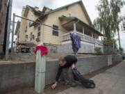 A Share House resident picks up around the exterior of the building in 2016.  Share's kitchen and public restrooms are currently closed for remodeling. Although water to the ground floor was shut off and the entrance was barricaded, people have broken in to relieve themselves, said Amy Reynolds, deputy director of Share.