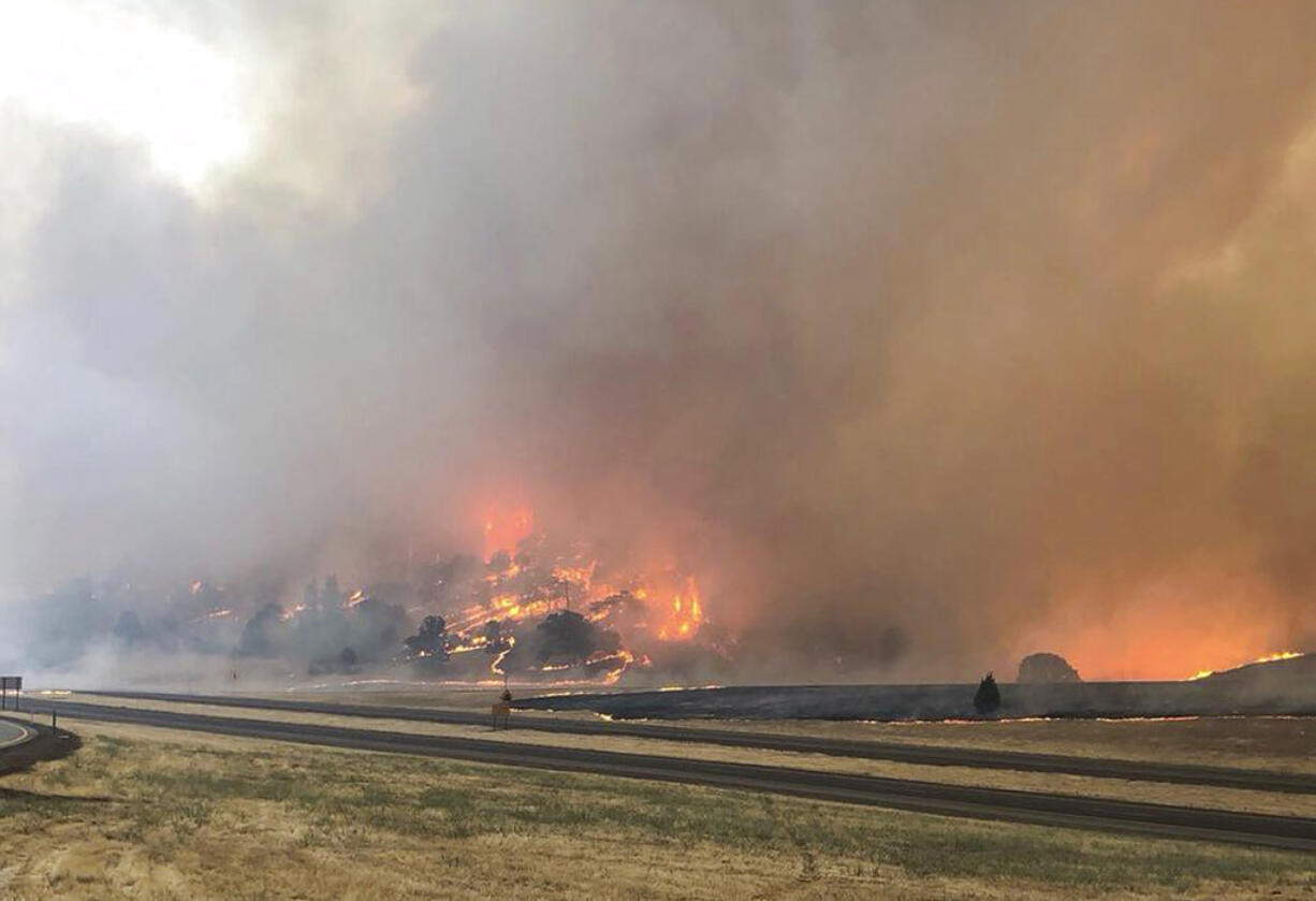 In this photo released Friday, July 6, 2018, by the California Highway Patrol, the Klamathon Fire burns in Hornbrook, Calif. A local California official says a deadly blaze burning near the Oregon border moved swiftly through the rural area that is home to many retirees. Siskiyou County Board of Supervisors chair Ray Haupt says the blaze moved so fast it quickly reached Hornbrook, a community of about 250 people about 14 miles (22 kilometers) south of the Oregon border. Authorities said one person was killed in the fire.