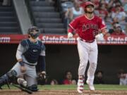 Los Angeles Angels' Francisco Arcia, right, watches his three-run home run next to Seattle Mariners catcher Mike Zunino during the third inning of baseball game in Anaheim, Calif., Saturday, July 28, 2018.