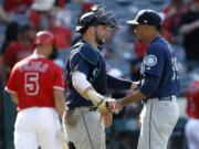 Seattle Mariners catcher Mike Zunino, center, congratulates relief pitcher Edwin Diaz, right, after Diaz struck out Los Angeles Angels designated hitter Albert Pujols, left, swinging, during the ninth inning of a baseball game in Anaheim, Calif., Sunday, July 29, 2018.