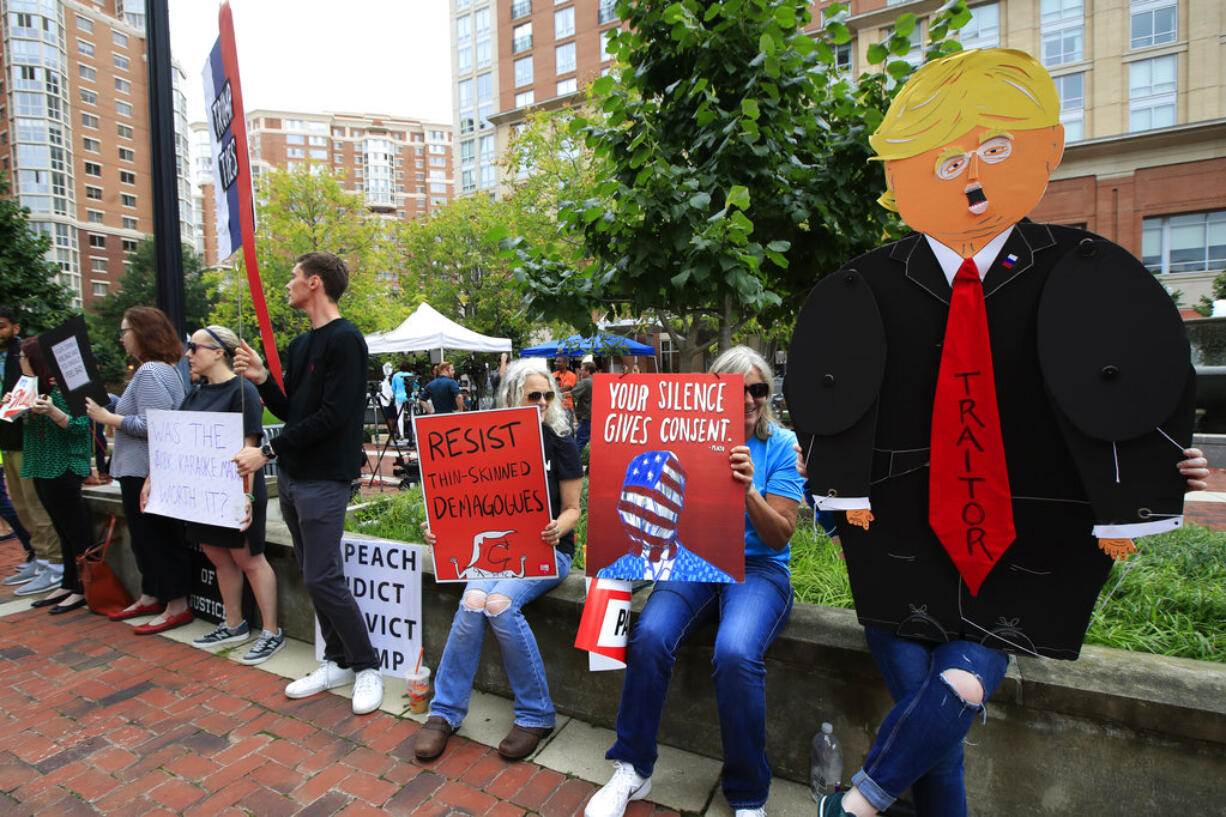 Protesters hold their banners in front of the Alexandria Federal Court in Alexandria, Va., Tuesday, July 31, 2018, on day one of Paul Manafort's trial.