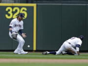 The ball hit by Los Angeles Angels’ Kole Calhoun drops between Seattle Mariners right fielder Ben Game and second baseman Dee Gordon during eighth inning of a baseball game Wednesday, July 4, 2018, in Seattle.