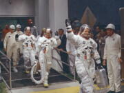 FILE - In this July 16, 1969, file photo, Neil Armstrong waving in front, heads for the van that will take the crew to the rocket for launch to the moon at Kennedy Space Center in Merritt Island, Fla. When Armstrong became the first man to walk on the moon, he captured the attention and admiration of millions of people around the world. Now fans of Armstrong and of space exploration have a chance to own artifacts and mementos that belonged to the modest man who became a global hero. The personal collection of Armstrong, who died in 2012, will be offered for sale in a series of auctions handled by Dallas-based Heritage Auctions.