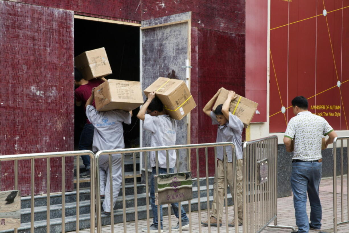 Workers carry boxes of LED lights into a renovation site in Beijing, China, on Tuesday. Barring a last-minute breakthrough, the Trump administration on Friday will start imposing tariffs on $34 billion in Chinese imports. And China will promptly strike back with tariffs on an equal amount of U.S. exports.