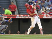 Los Angeles Angels’ Mike Trout, right, hits a solo home run as Los Angeles Dodgers catcher Yasmani Grandal watches during the sixth inning of a baseball game Saturday, July 7, 2018, in Anaheim, Calif. (AP Photo/Mark J.