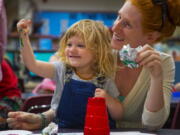 In this May 10, 2018 photo, Harley, 2, and Reagan Rufner participate in painting time in the 1-2-3- Grow & Learn program in the library at Roosevelt Elementary in Vancouver, Wash.