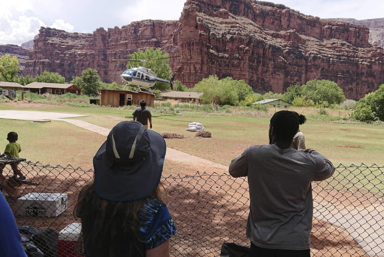 A helicopter landing to rescue people from flooding on the Havasupai reservation in Supai, Ariz. Rescue workers were evacuating about 200 tourists Thursday who were caught in flash flooding at a popular campground on tribal land near the Grand Canyon where visitors go to see towering blue-green waterfalls.