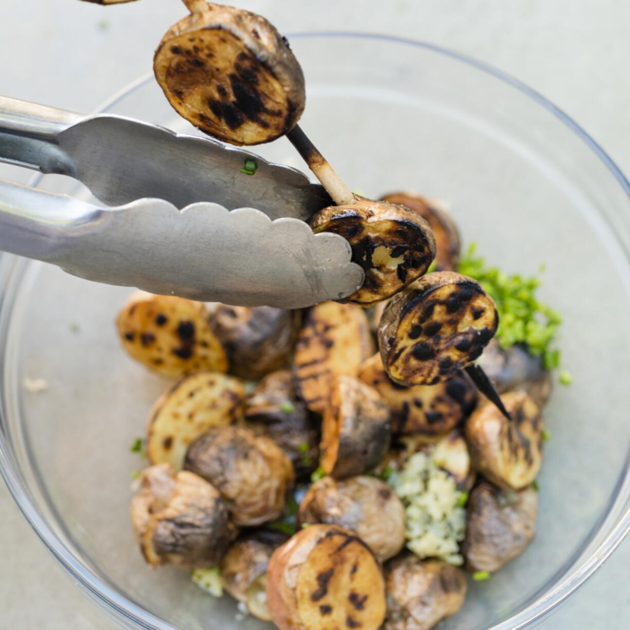 Grilled potatoes with garlic and rosemary in Brookline, Mass. This recipe appears in the cookbook “Master of the Grill.” (Daniel J.