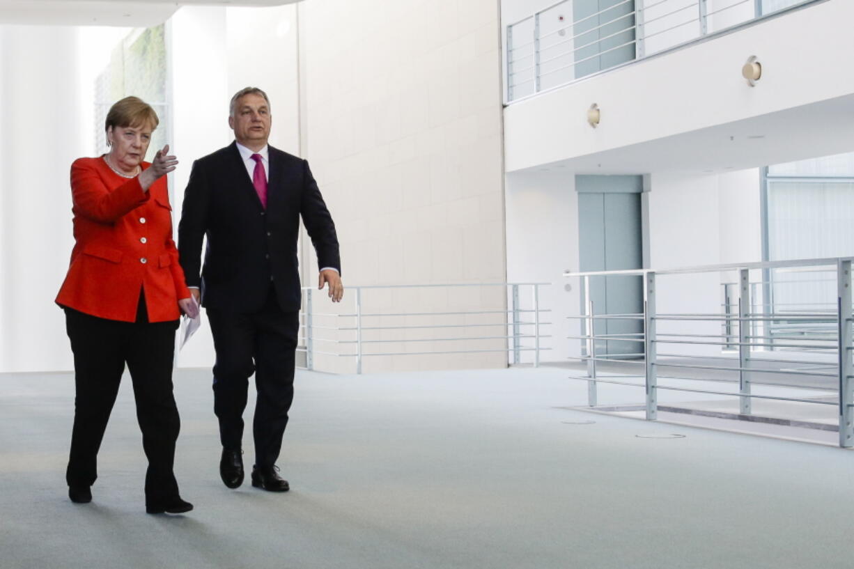 German Chancellor Angela Merkel, left, and Hungarian Prime Minister Viktor Orban, right, arrive for a news conference after a meeting at the chancellery in Berlin, Thursday.