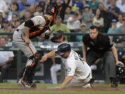 Seattle Mariners’ Kyle Seager is tagged out at home by San Francisco Giants catcher Buster Posey as he tried to score on a single by Mike Zunino during the fourth inning of a baseball game Tuesday, July 24, 2018, in Seattle. (AP Photo/Ted S.