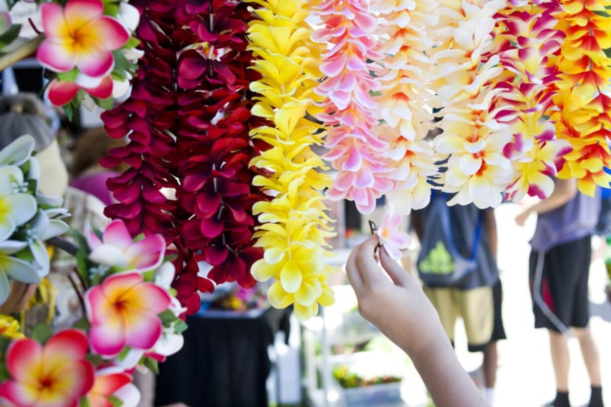 Brightly colored leis hang from a vendor booth at the annual Hawaiian Festival in Esther Short Park.