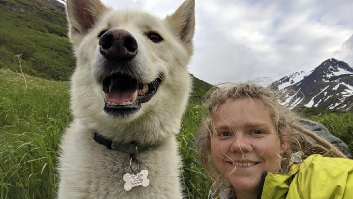 Amelia Milling is seen June 19 with a 7-year-old Alaskan husky named Nanook that is credited with helping rescue her when she was injured while hiking a trail in the Chugach State Park east of Anchorage, Alaska. She says the dog found her after she tumbled down a slope.